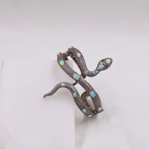 Decorative brooch with snake design on a white background