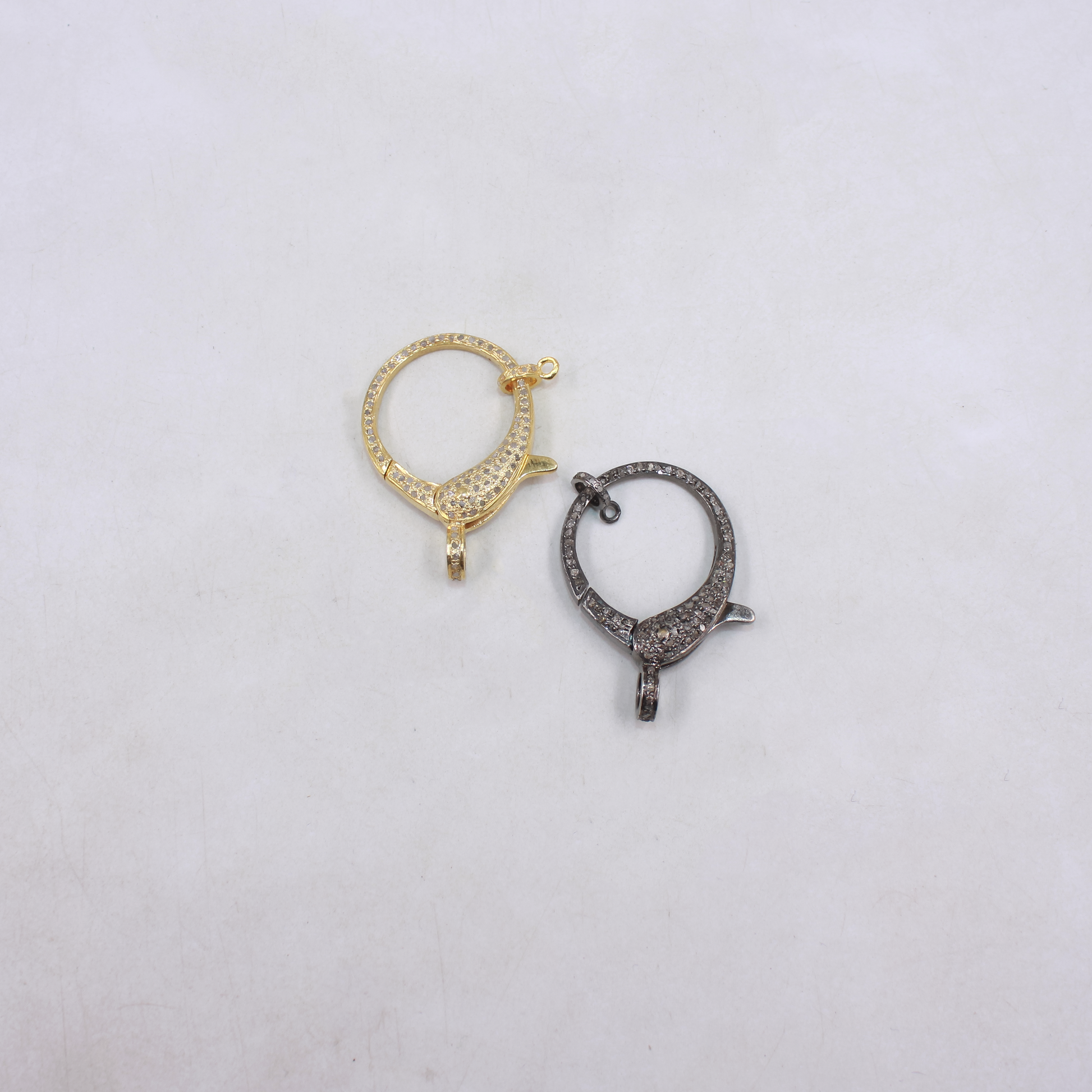 Two gold and silver hoop earrings on a light gray background