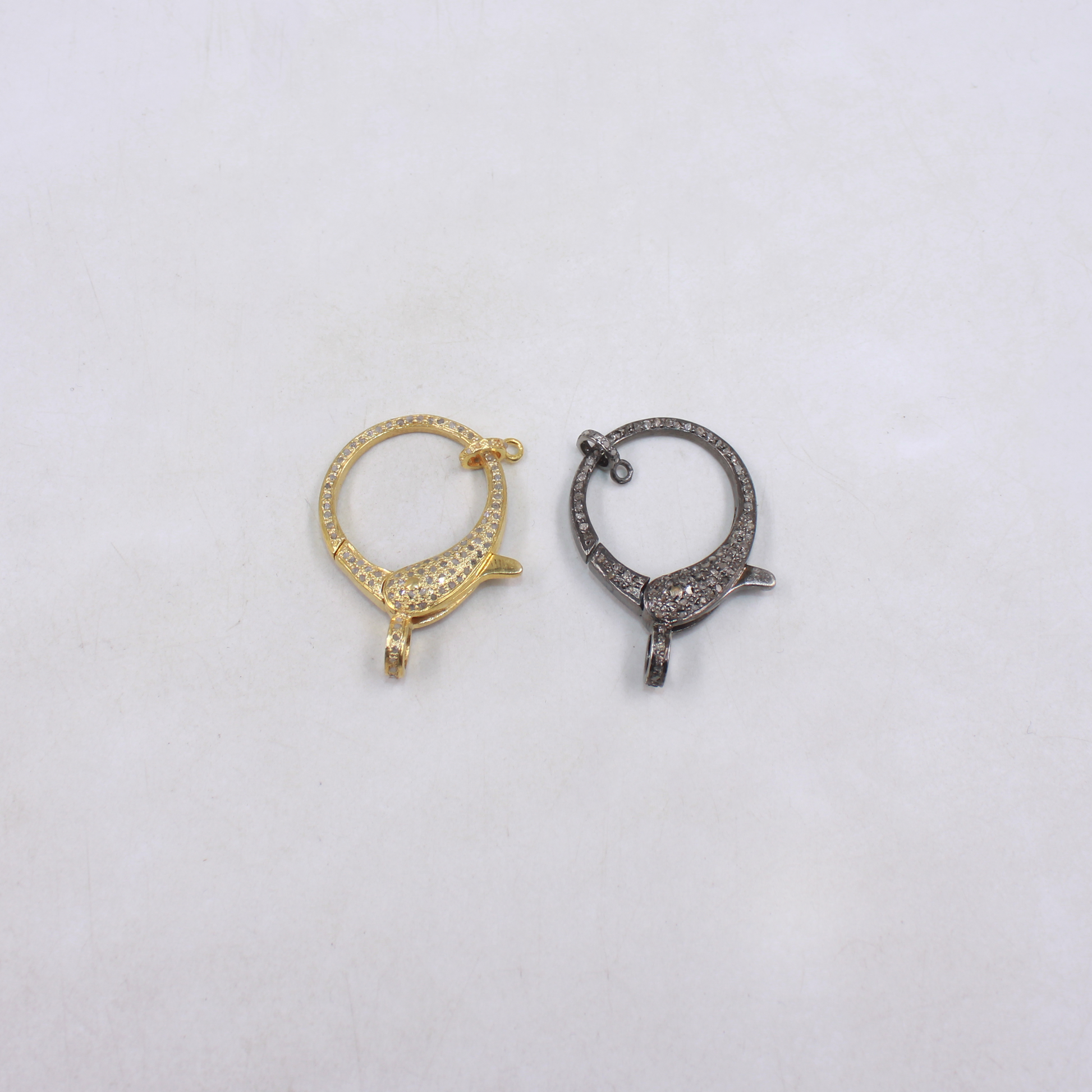 Two gold and silver hoop earrings on a light gray background
