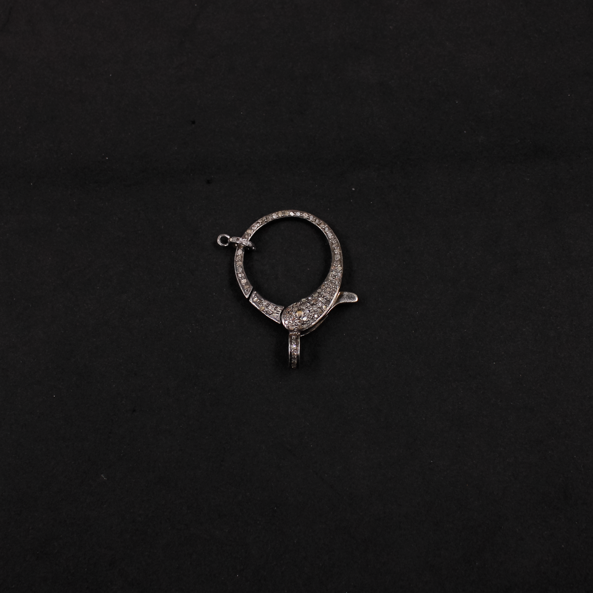Silver earring on a black background