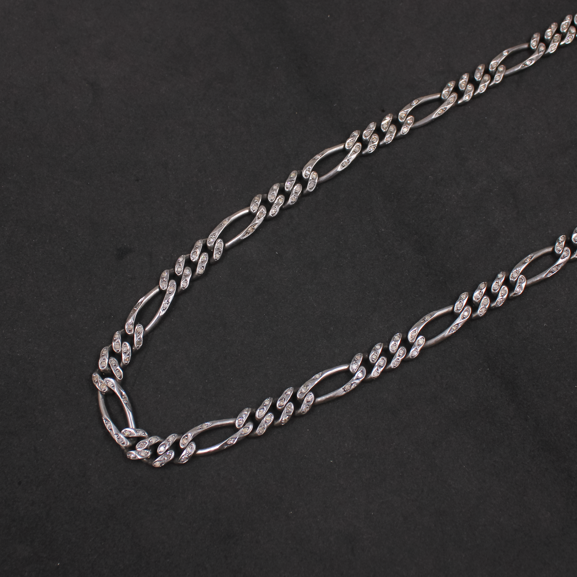 Silver chain necklace on a black background