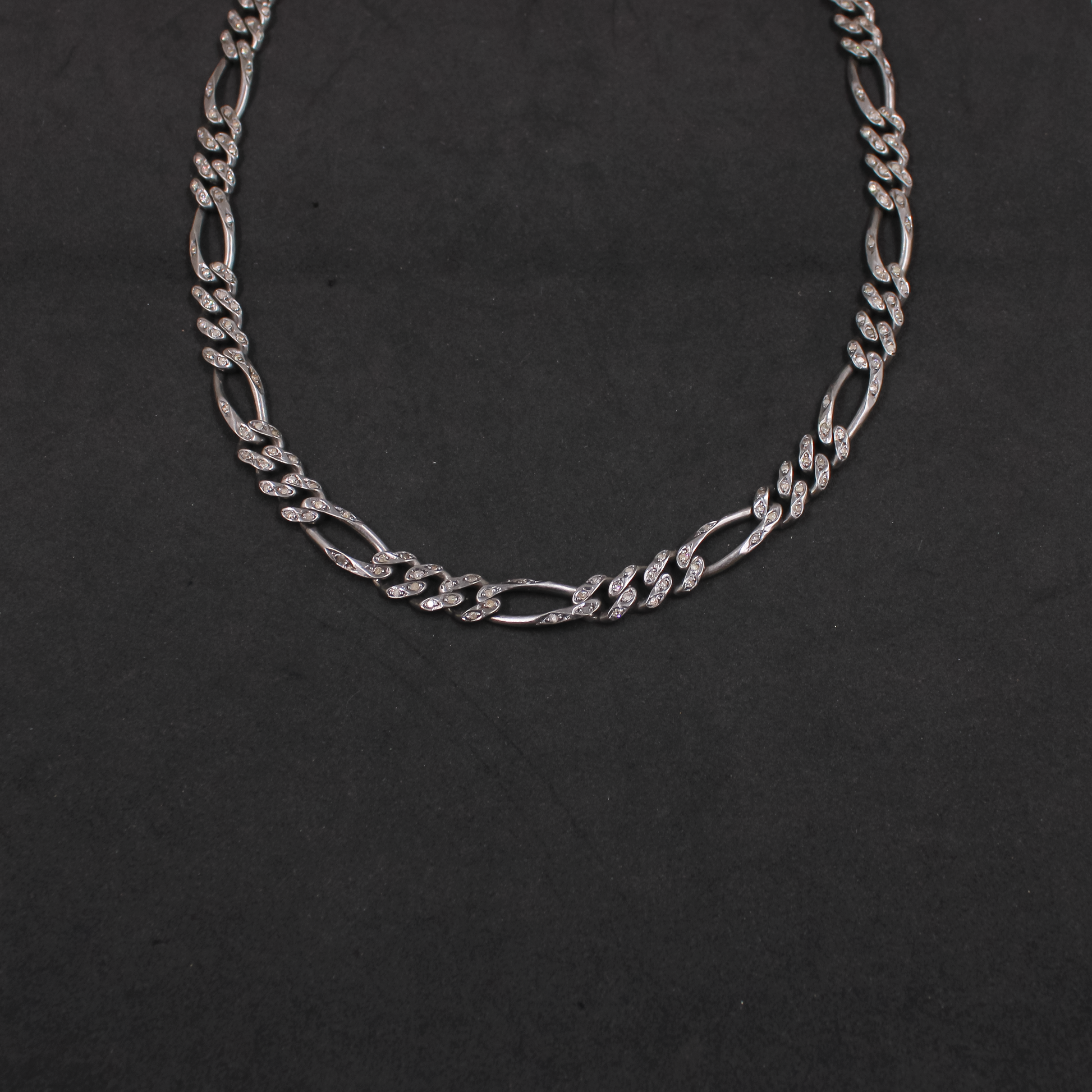 Silver chain necklace on a black background