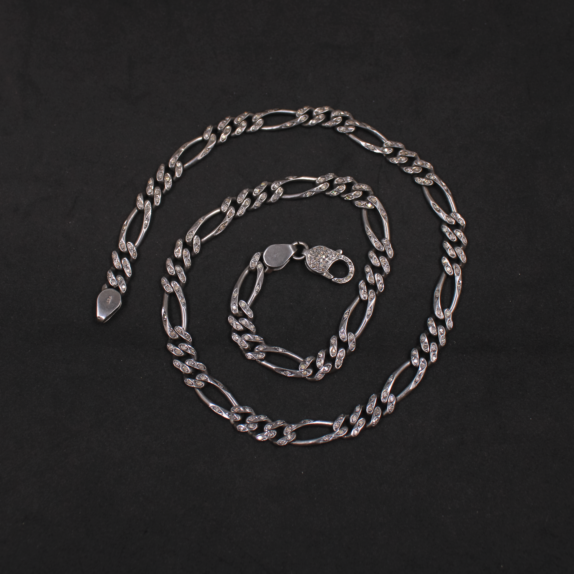 Silver chain necklace on a black background