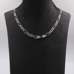 Silver chain necklace on a black mannequin bust against a white background