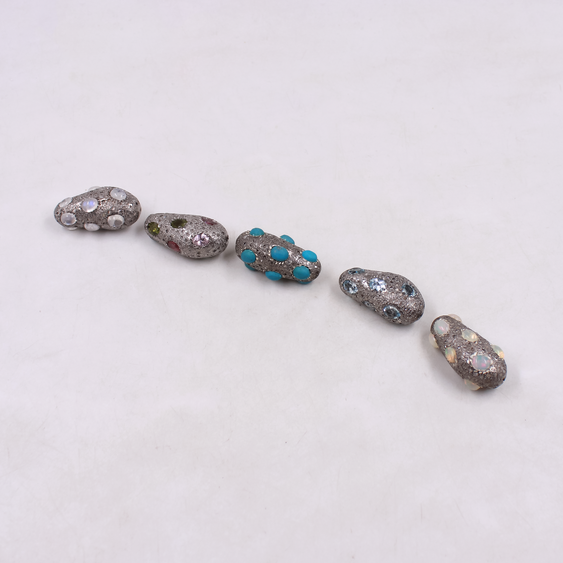 Sterling silver jewelry bead with artistic diamond and gemstone placement.