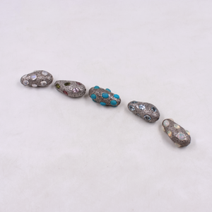 Sterling silver jewelry bead with artistic diamond and gemstone placement.