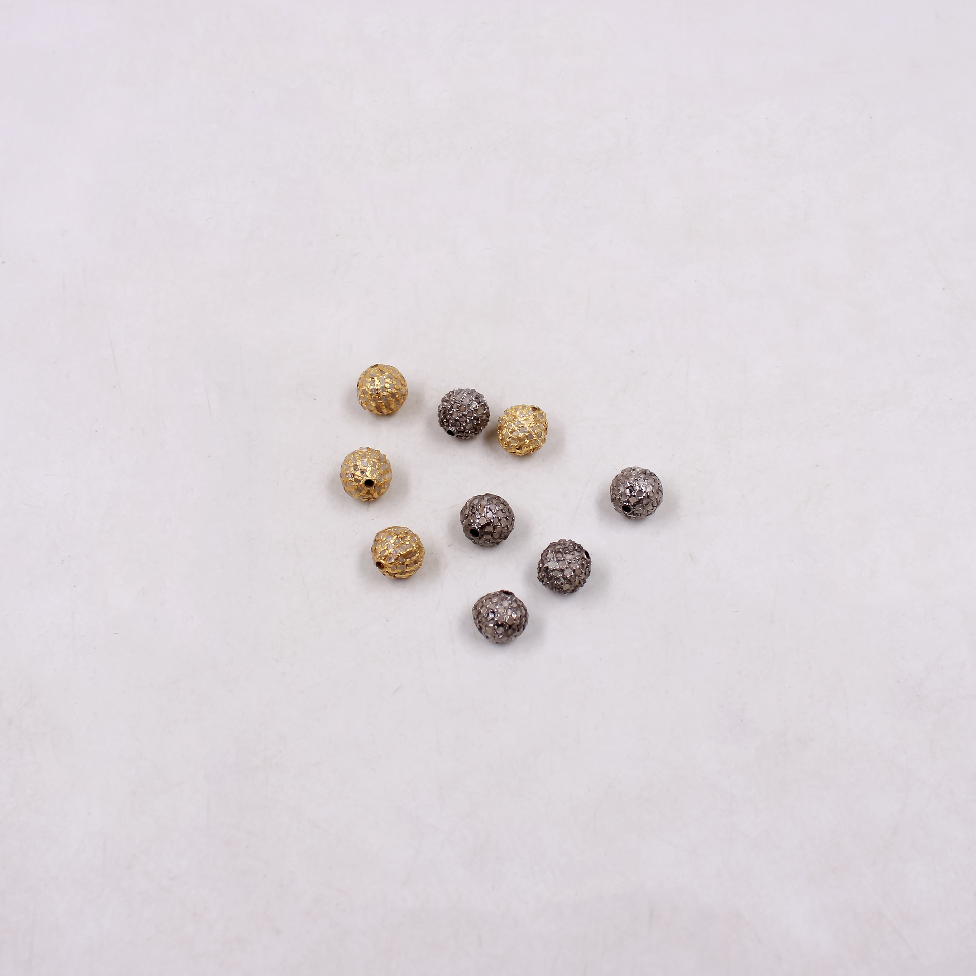 Gold and silver beads on a light gray background