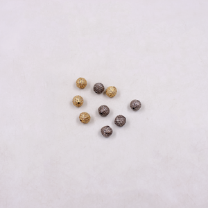 Gold and silver beads on a light gray background