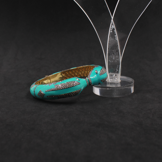 Turquoise bangle with decorative patterns on a black background