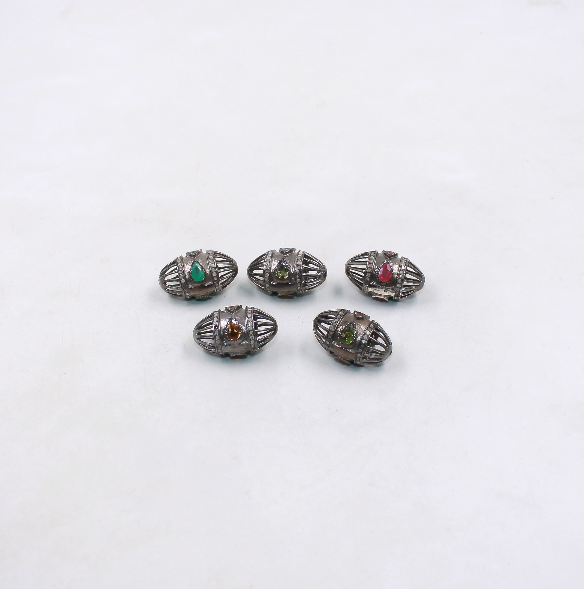 Five silver jewelry pieces with gemstones on a white background