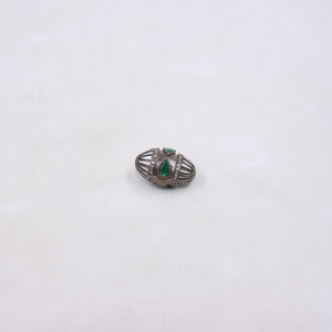 Silver brooch with green gemstones on a white background