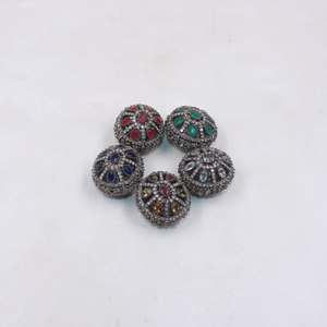 Five decorative beads with multicolored gemstones on a white background