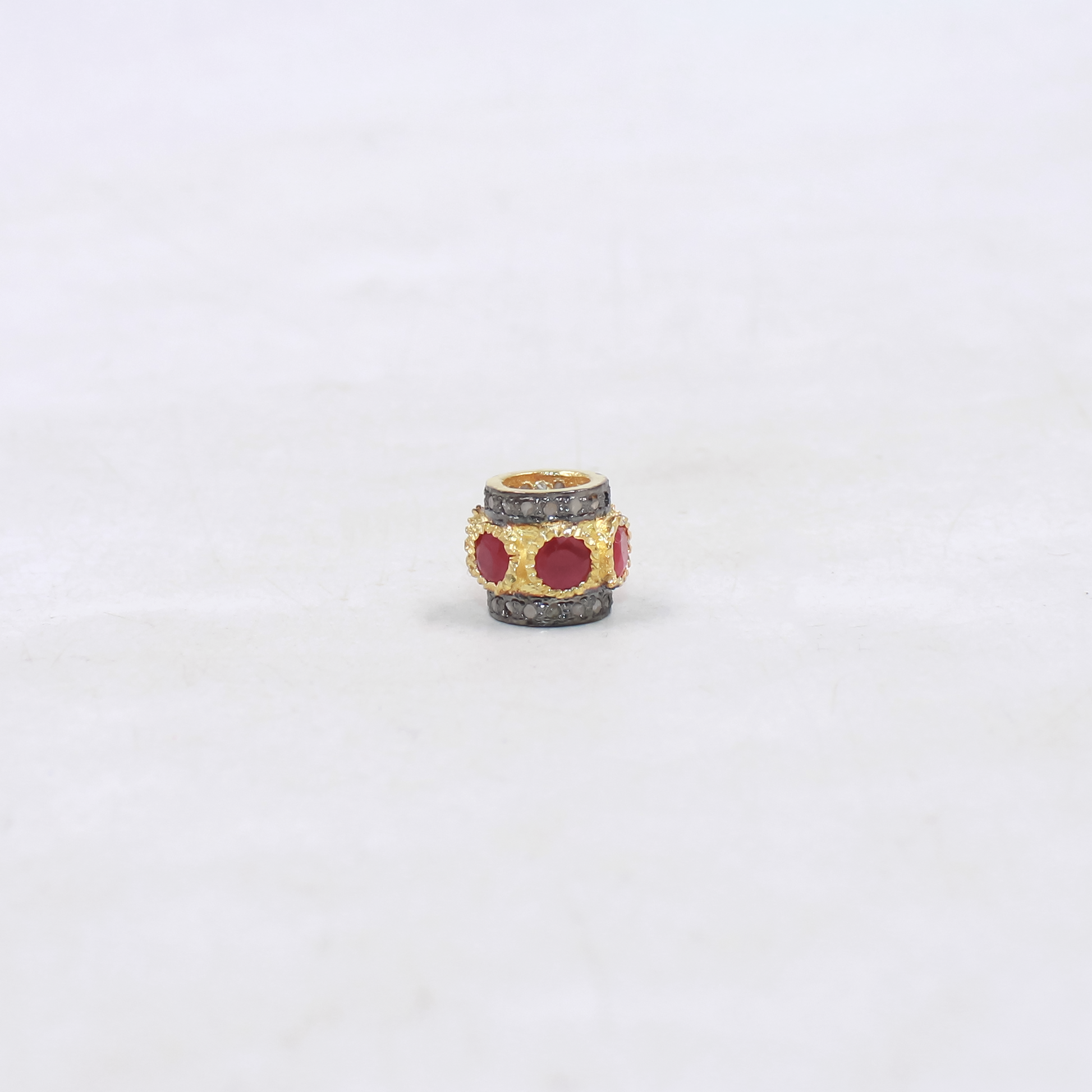 Decorative bead with red ruby on a white background