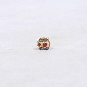 Decorative bead with red ruby on a white background