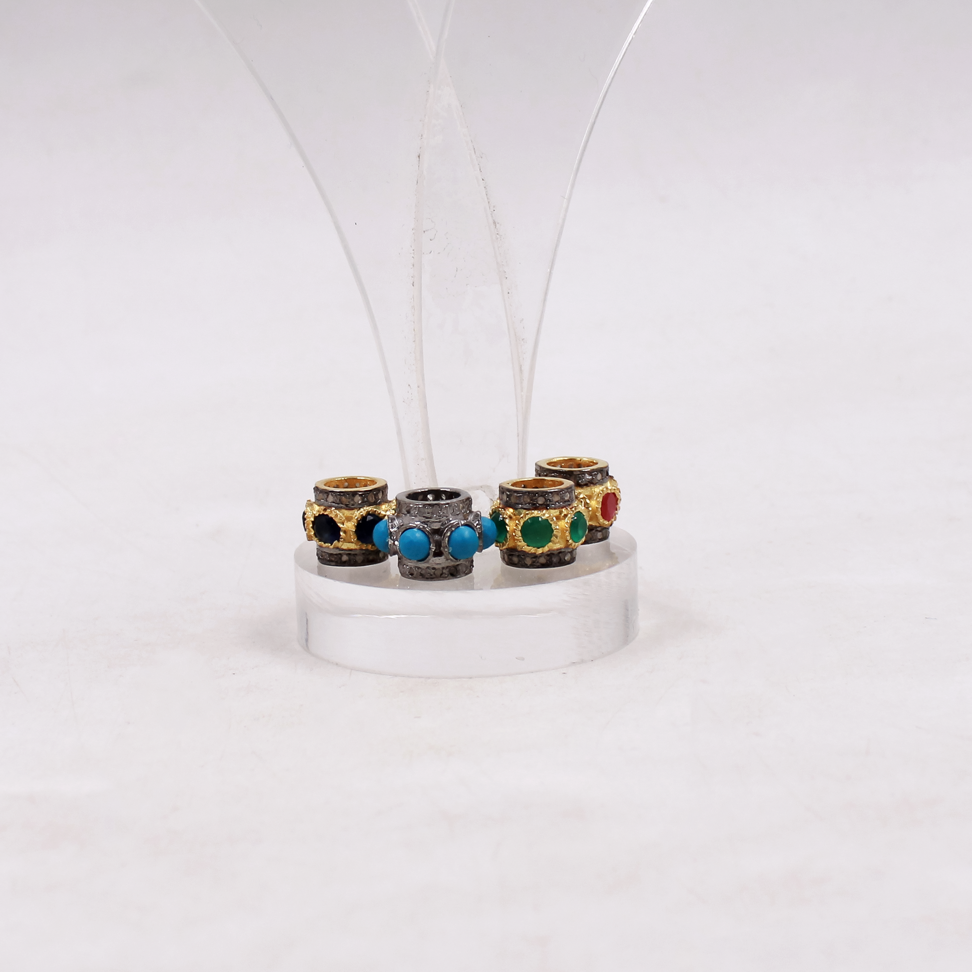 Set of five colorful beads on a white stand against a white background