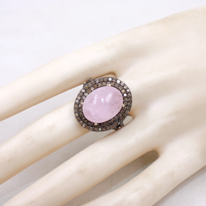 Ring with pink gemstone and diamond-like stones on a mannequin hand