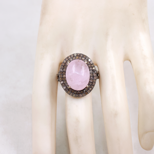Ring with a pink stone on a mannequin hand against a white background