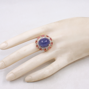 Ring with a purple gemstone on a mannequin hand against a white background