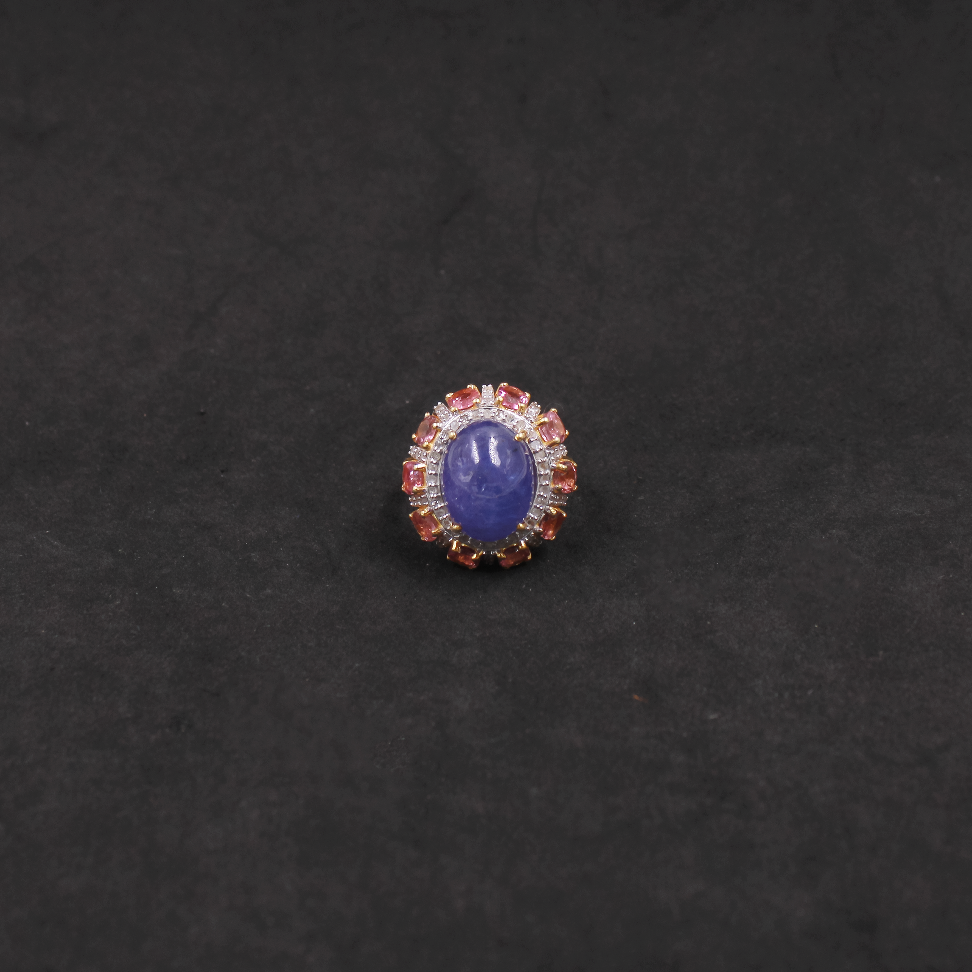 Ring with a blue gemstone and red accents on a black background
