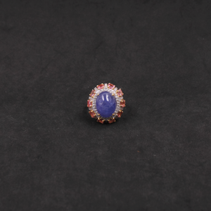 Ring with a blue gemstone and red accents on a black background