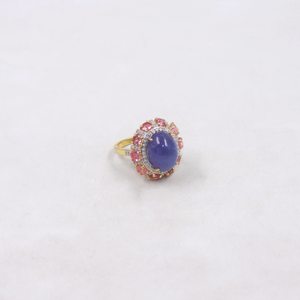 Ring with a purple gemstone and pink accents on a white background