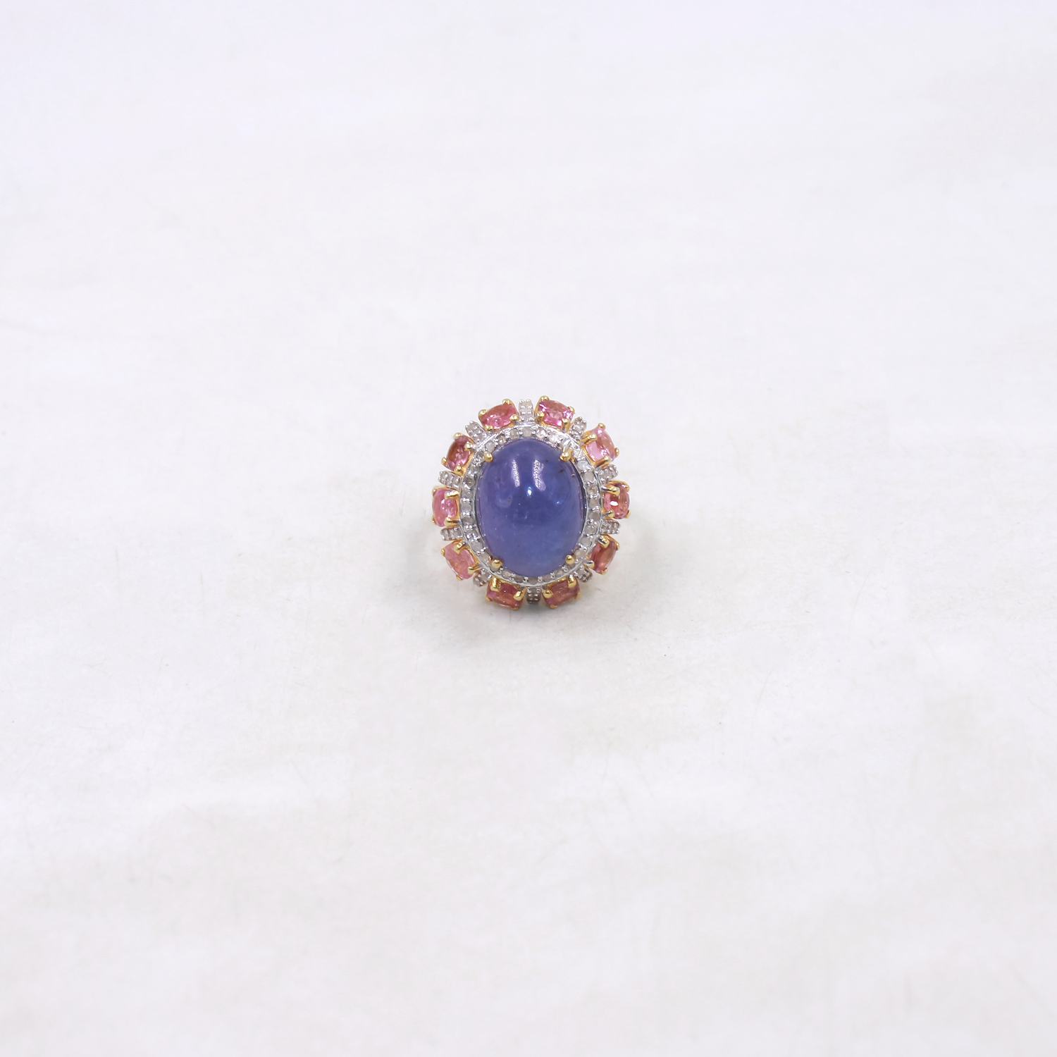 Ring with a purple gemstone and pink accents on a white background