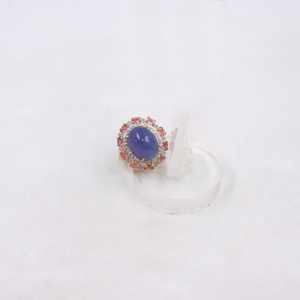 Ring with a purple gemstone and pink accents on a white background