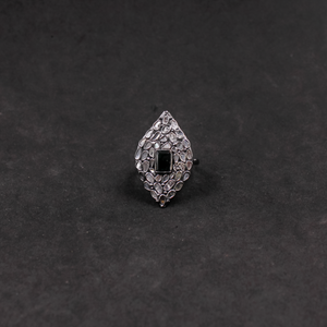 Silver ring with black gemstone on a dark gray background