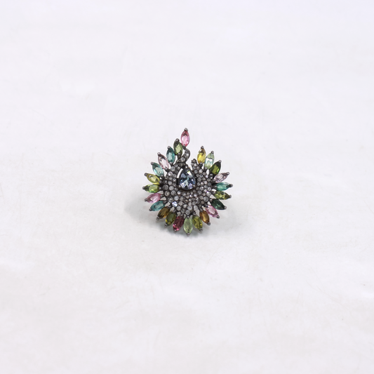 Multicolored gemstone ring on a light gray background