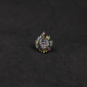 Decorative brooch with multicolored gemstones on a black background