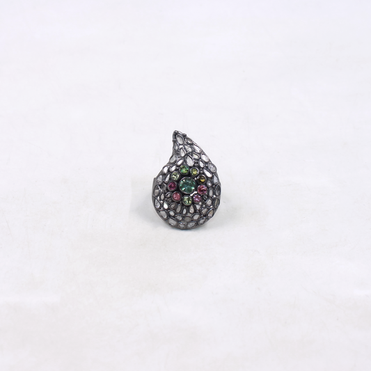Teardrop-shaped ring with gemstones on a white background