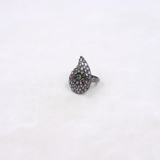 Teardrop-shaped ring with colorful gemstones on a white background