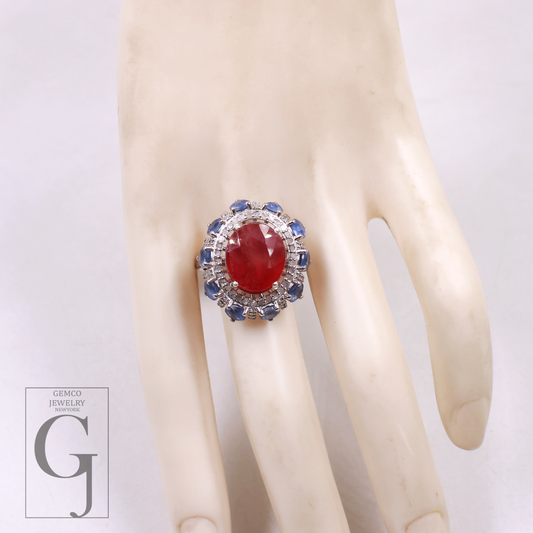 Ring with a red gemstone and blue accents on a mannequin hand, with 'GEMCO JEWELRY' branding.