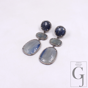 Pair of earrings with Blue Sapphire on a white background, featuring the Gemco Jewelry logo.