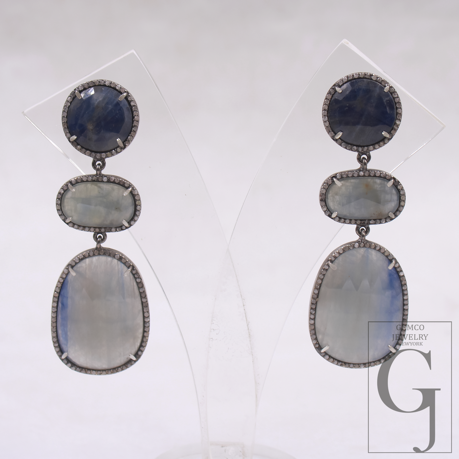 Pair of earrings with layered gemstones on a white background