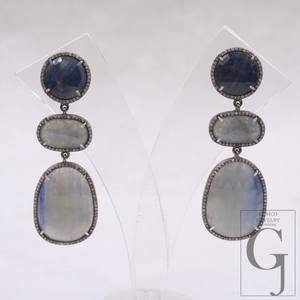 Pair of earrings with layered gemstones on a white background