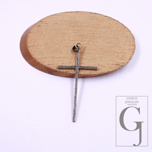 Silver cross pendant on a wooden stand with Gemco Jewelry.