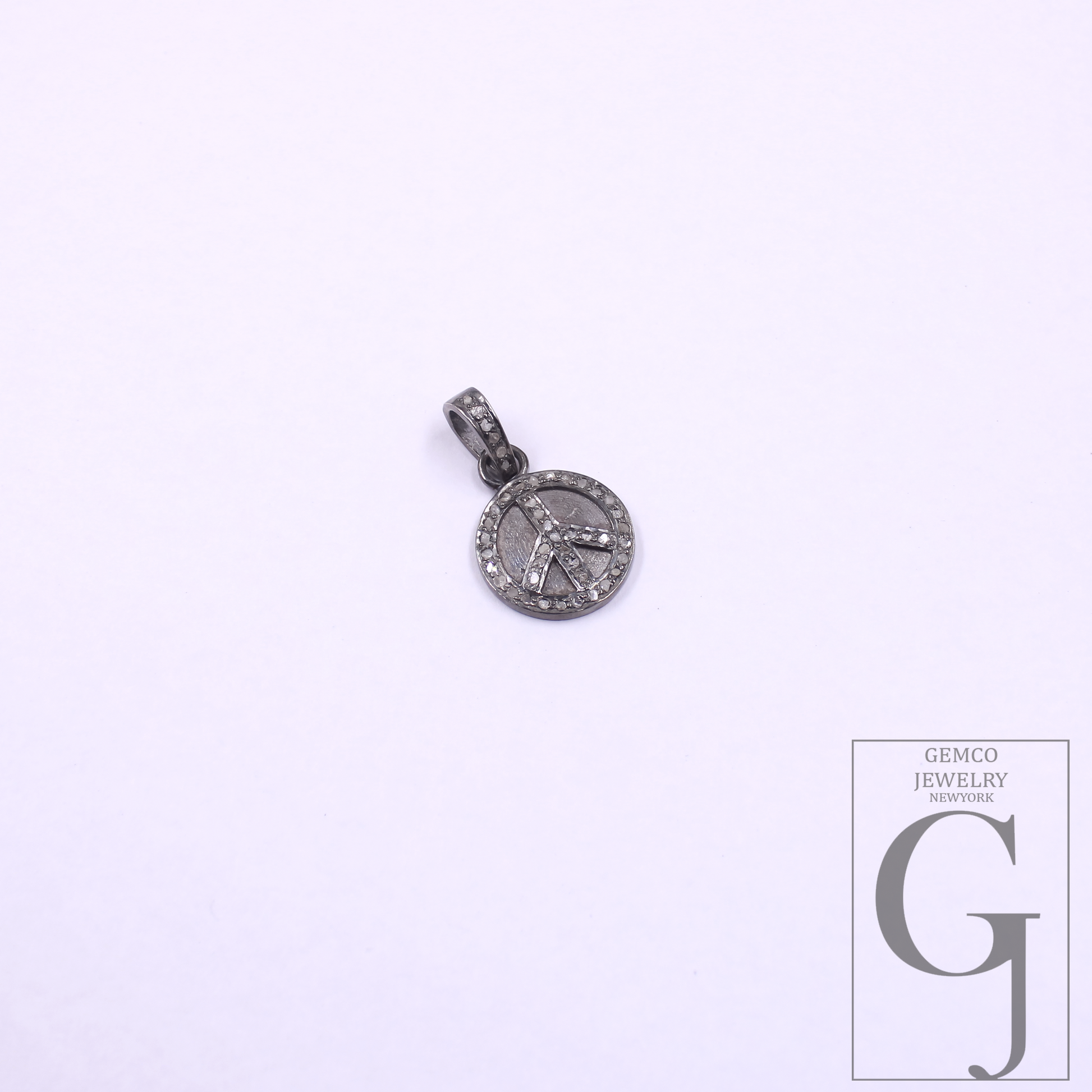 Silver pendant with peace symbol on a white background, featuring Gemco Jewelry New York logo.
