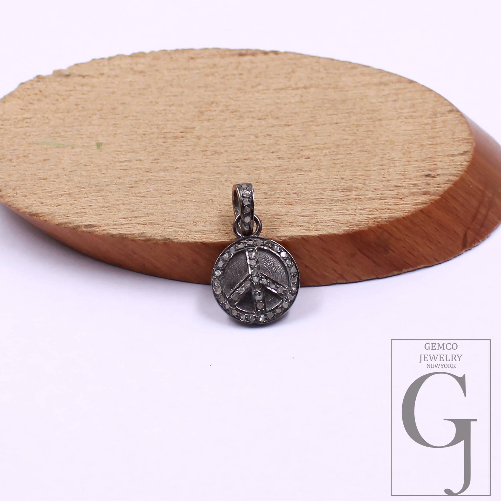Silver peace sign pendant on a wooden disc with Gemco Jewelry New York logo.