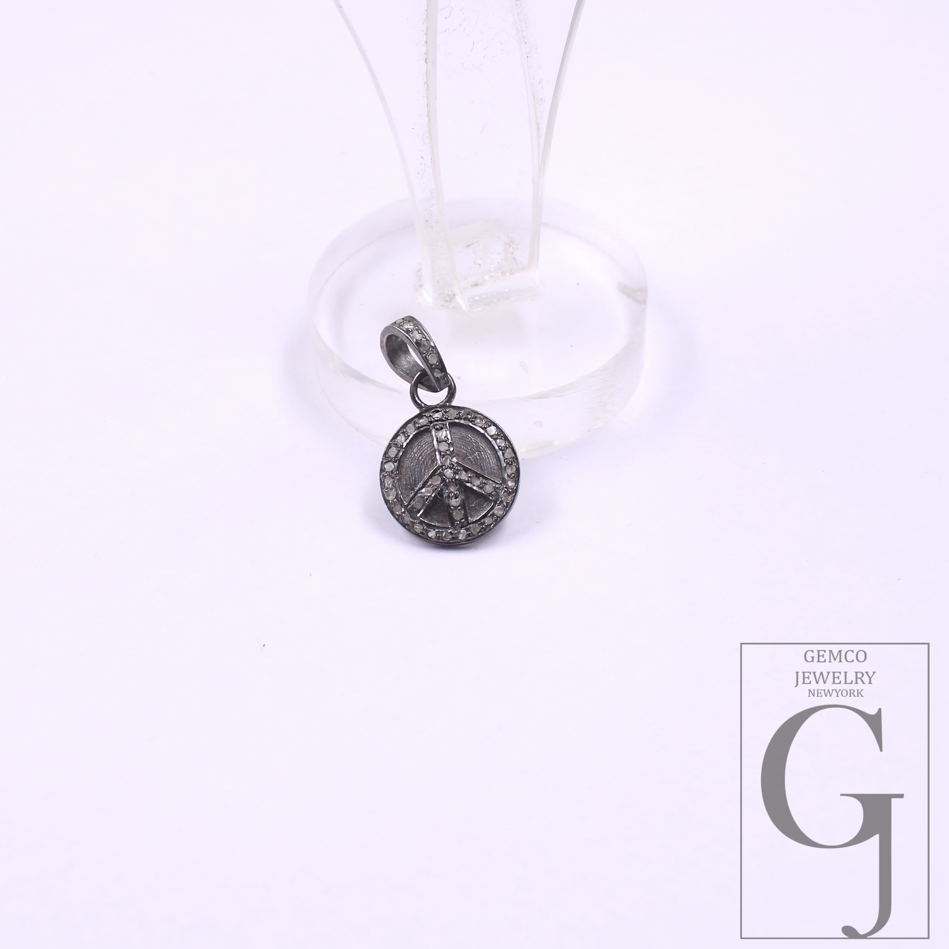 Silver peace sign pendant on a white background with Gemco Jewelry New York logo.