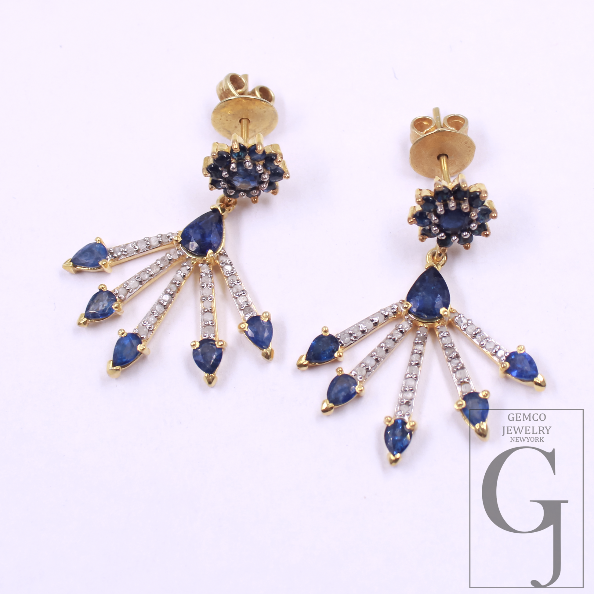 Gold earrings with blue gemstones and diamonds on a white background, featuring Gemco Jewelry logo.