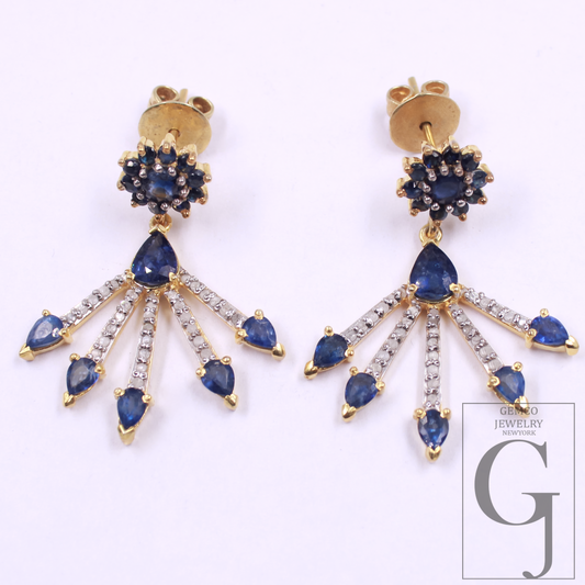 Pair of gold earrings with blue gemstones and clear stones on a white background