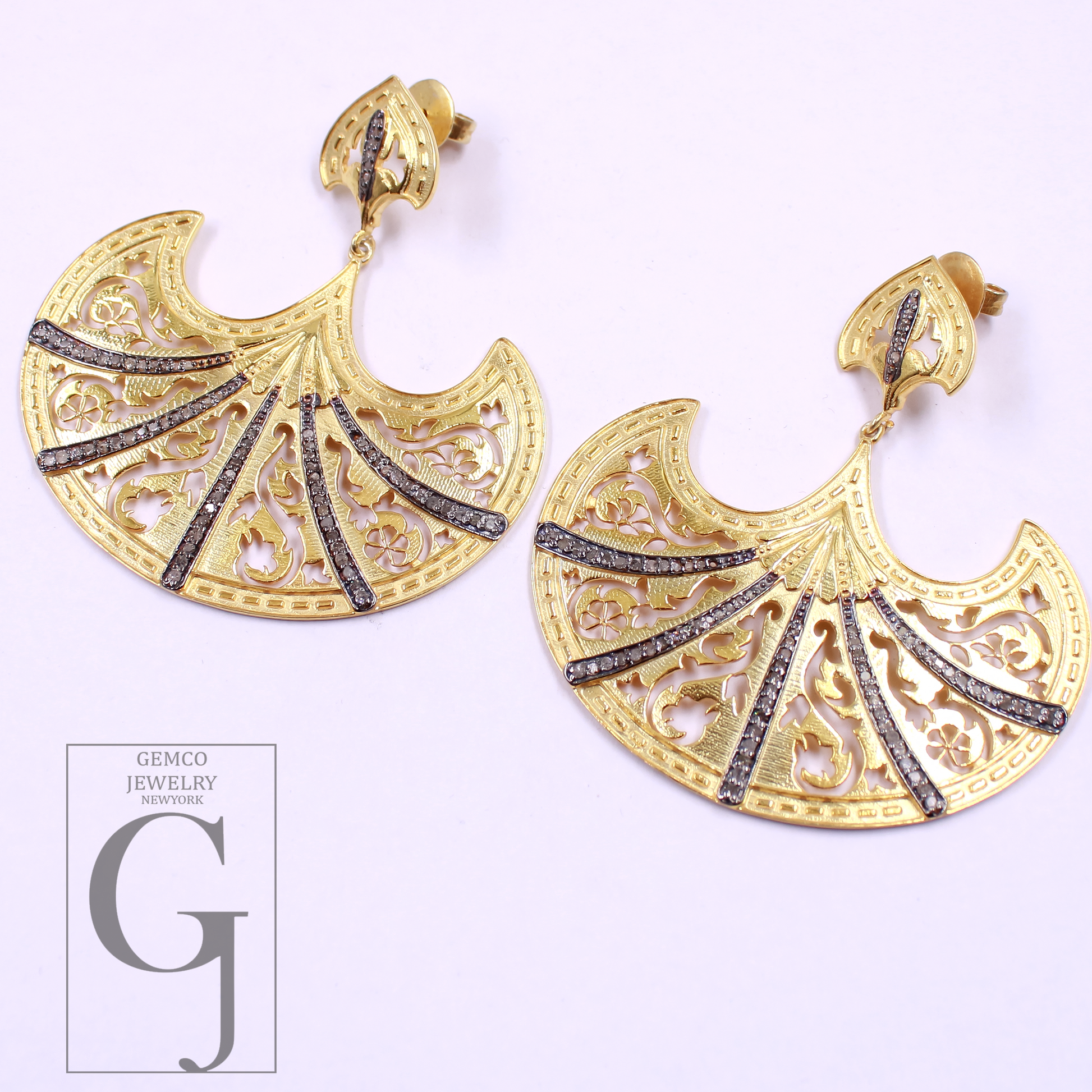 Gold earrings with intricate designs on a white background, featuring the Gemco Jewelry New York logo.