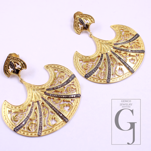 Gold and black earrings with intricate designs on a white background, featuring the Gemco Jewelry logo.