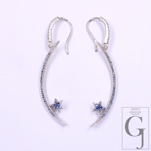 Silver earrings with star-shaped blue gemstones on a white background
