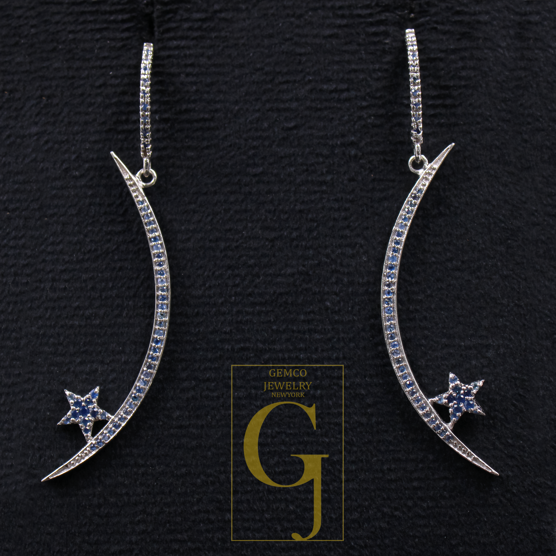 Crescent moon and star earrings on a black background with Gemco Jewelry logo.