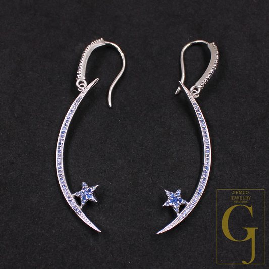 Silver earrings with star and moon designs on a black background, featuring Gemco Jewelry branding.