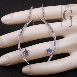 Crescent moon and star earrings on a hand with Gemco Jewelry logo.