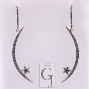 Pair of earrings with blue gemstones on a white background with Gemco Jewelry logo.