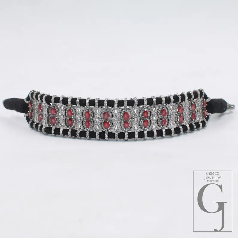 Decorative headband with red stones and black accents on a white background